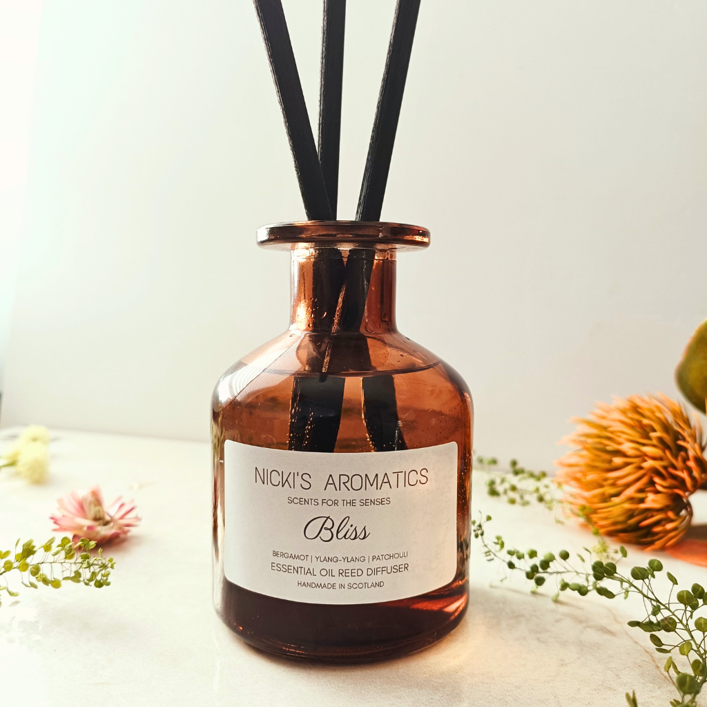 Bliss natural essential oil reed diffuser in an apothecary style amber glass jar with black fibre reeds