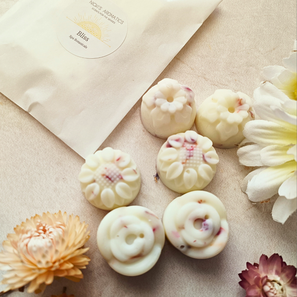 6 Bliss essential oil wax melts next to a glassine bag containing a Bliss wax melt bar