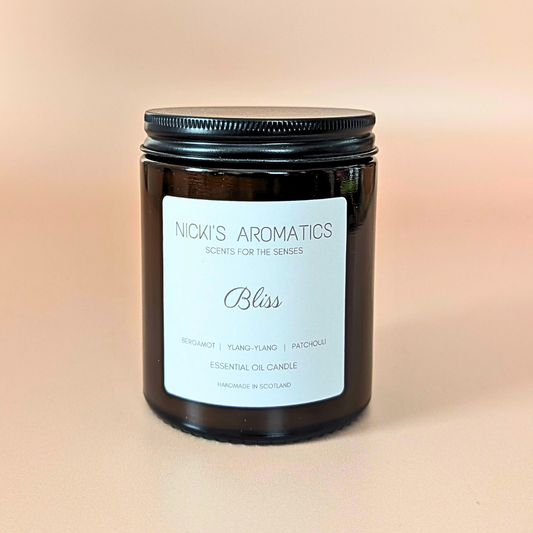 Bliss essential oil candle with bergamot, ylang-ylang and patchouli in an amber glass jar