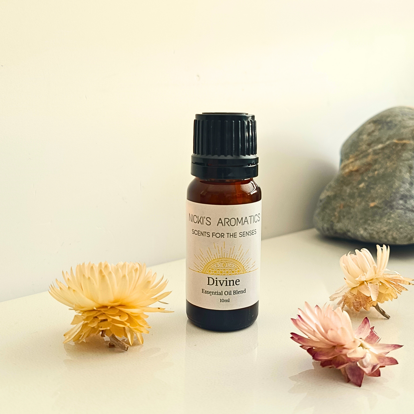 A 10ml amber glass bottle of Divine essential oil blend