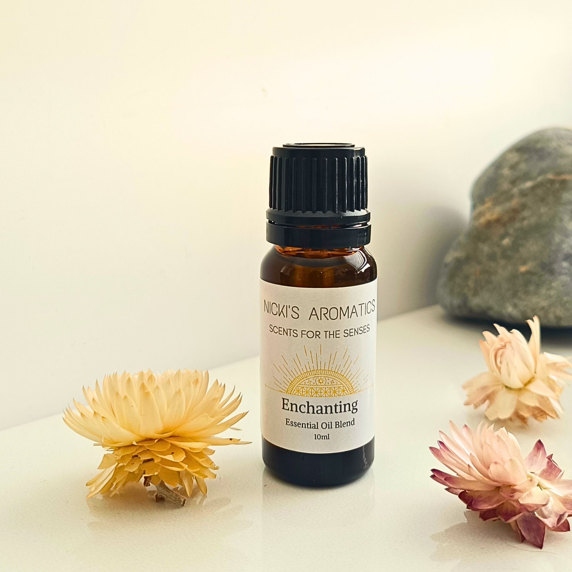A 10ml amber glass bottle of Enchanting essential oil blend