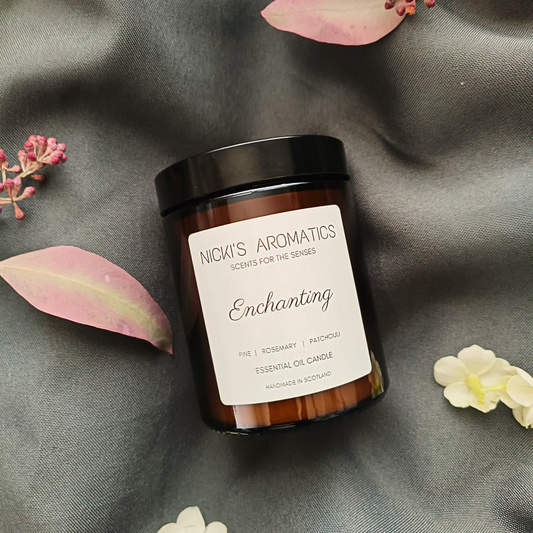 Enchanting essential oil candle in an amber glass jar resting o a grey sheet