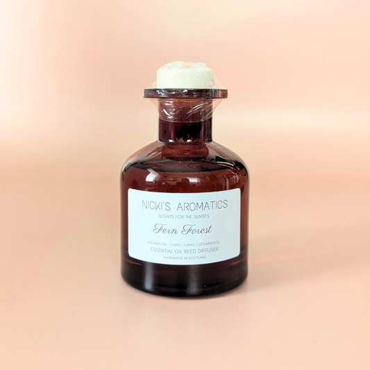 Bliss essential oil reed diffuser with palmarosa, ylang-ylang and cedarwood in an amber glass bottle