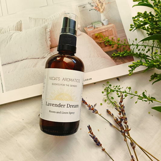 Lavender Dream essential oil room linen and pillow spray in an amber glass bottle resting on an open magazine
