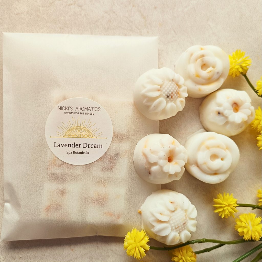 Lavender Dream essential oil wax melts in flower shapes next to a wax melt bar in a glassine bag