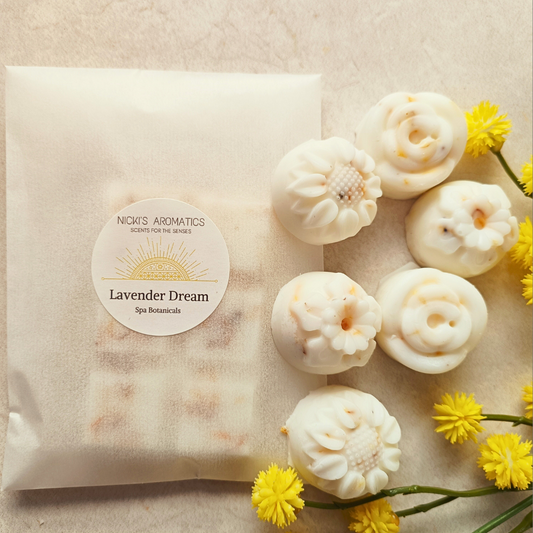 Lavender Dream essential oil wax melts in flower shapes next to a wax melt bar in a glassine bag