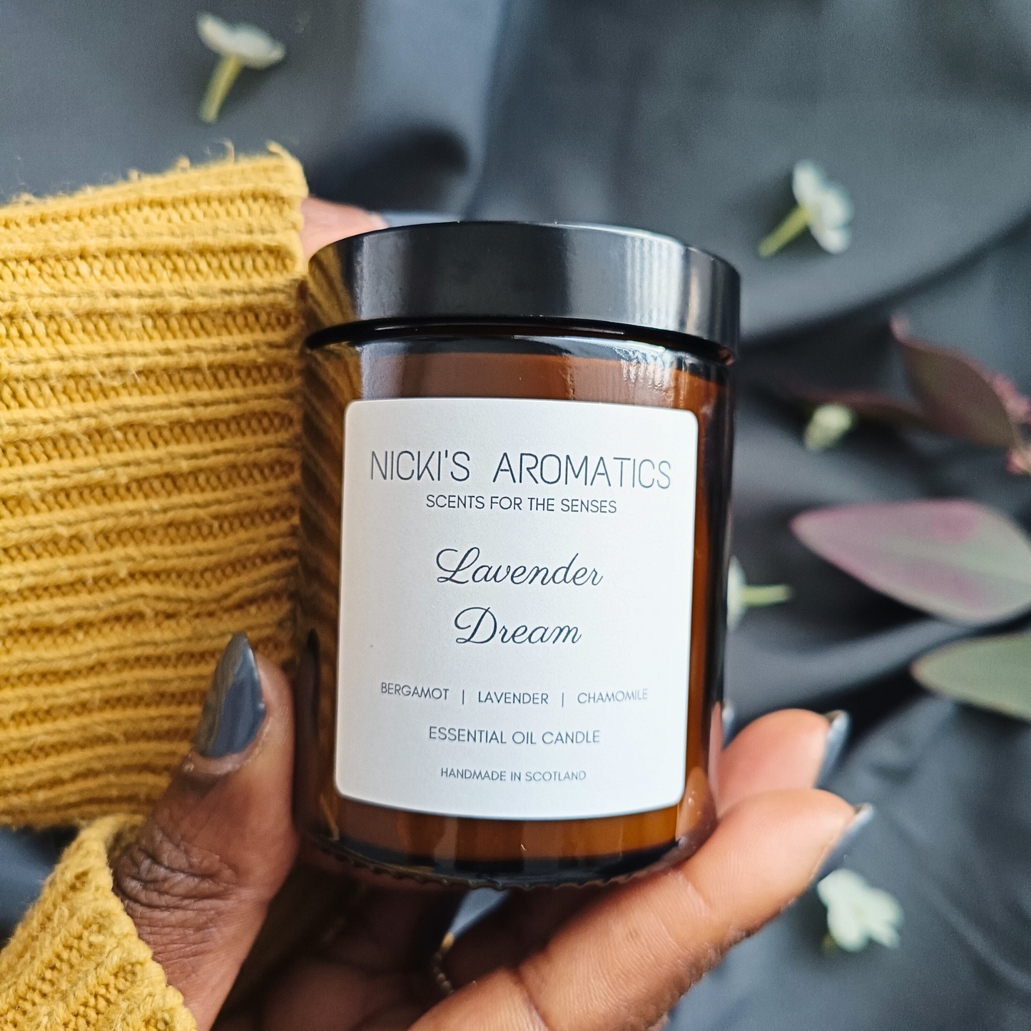 Lavender Dream essential oil candle being held in a pair of hands