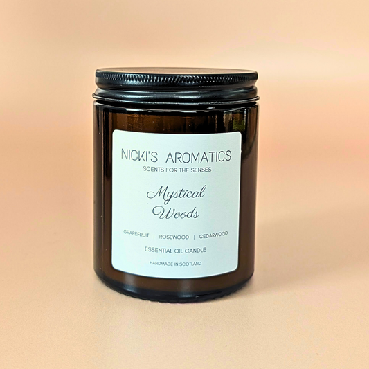 Mystical Woods essential oil candle with grapefruit, rosewood, patchouli and cinnamon in an amber glass jar