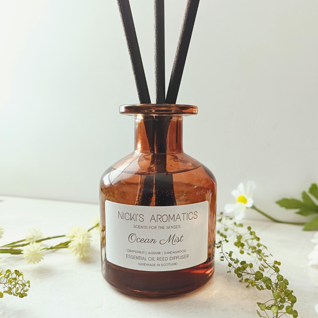 natural essential oil reed diffuser in an amber glass apothecary style bottle with black fibre reeds