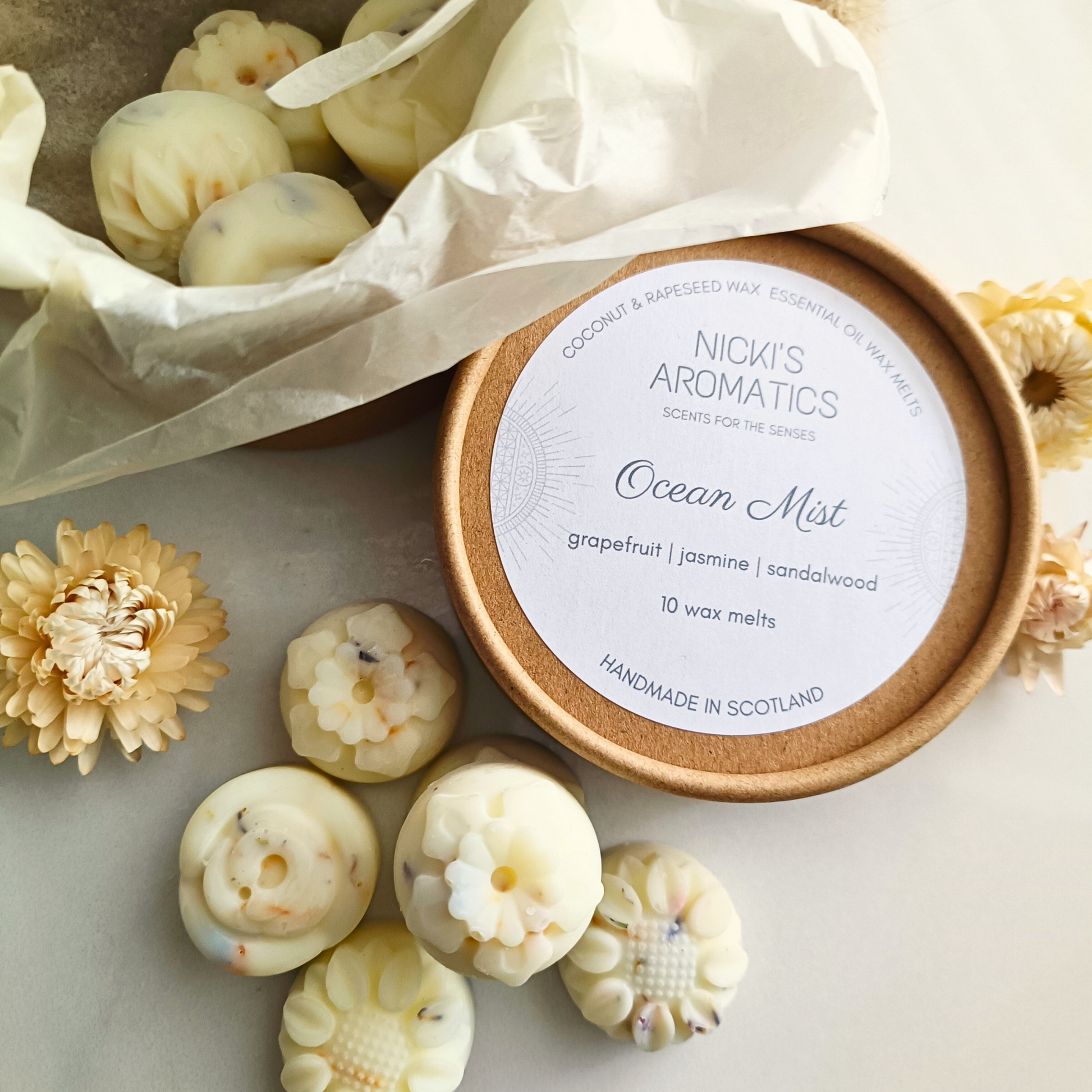 a kraft tub of individual flower-shaped wax melts with some in the tub and some next to it