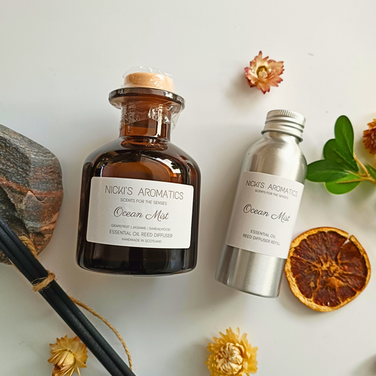 natural essential oil reed diffuser in an amber glass apothecary style bottle next to a 100ml aluminium refill bottle