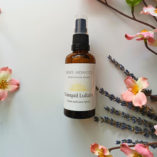 50ml amber glass botte of Tranquil Lullaby room and linen sprays next to dried lavender stems and flowers