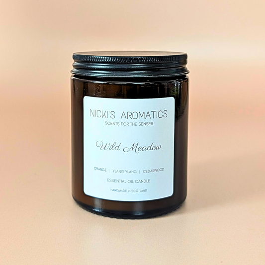 Wild Meadow essential oil candle with orange, ylang-ylang and cedarwood in an amber glass jar