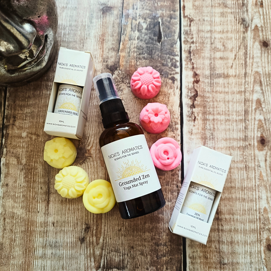Grounded Zen essential oil yoga mat spray in the middle of 6 flower-shaped wax melts and two 10ml bottles of essential oils