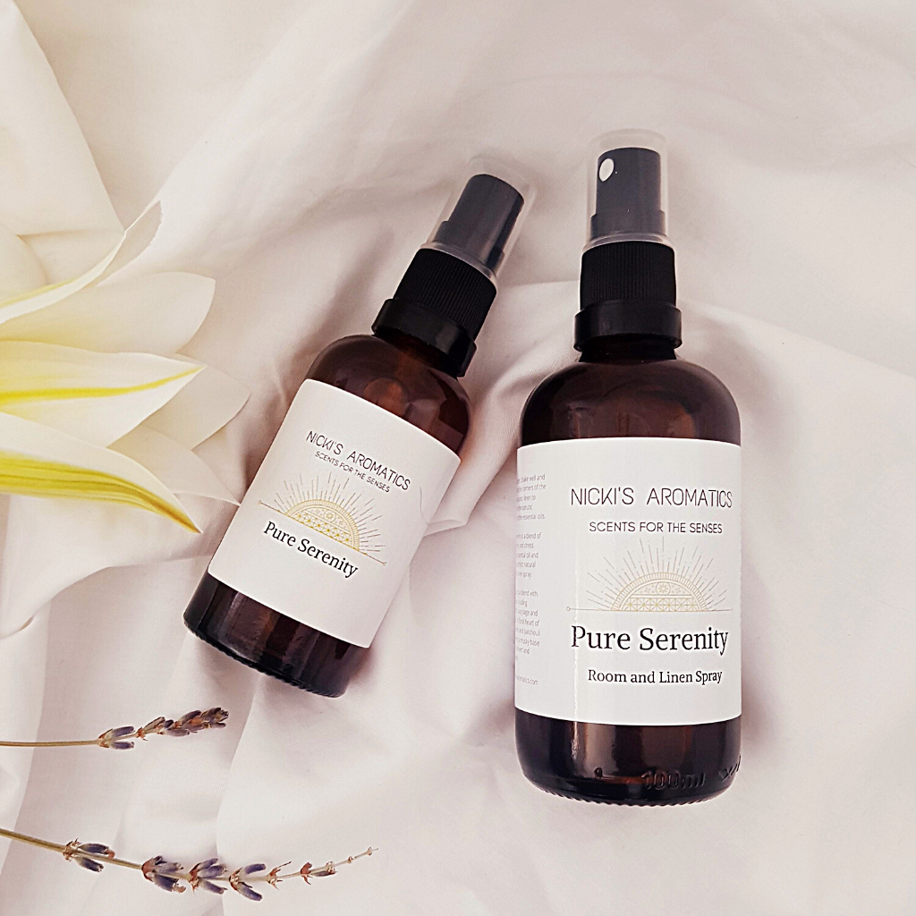 Pure Serenity natural room and linen sprays in a 50ml and 100ml amber glass bottle resting on a white sheet