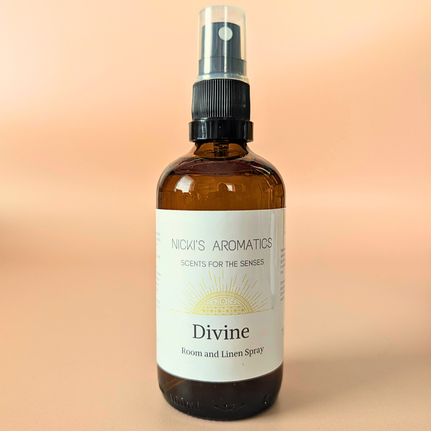 Divine natural room and linen spray with citrus, frangipani and basil in an amber glass bottle