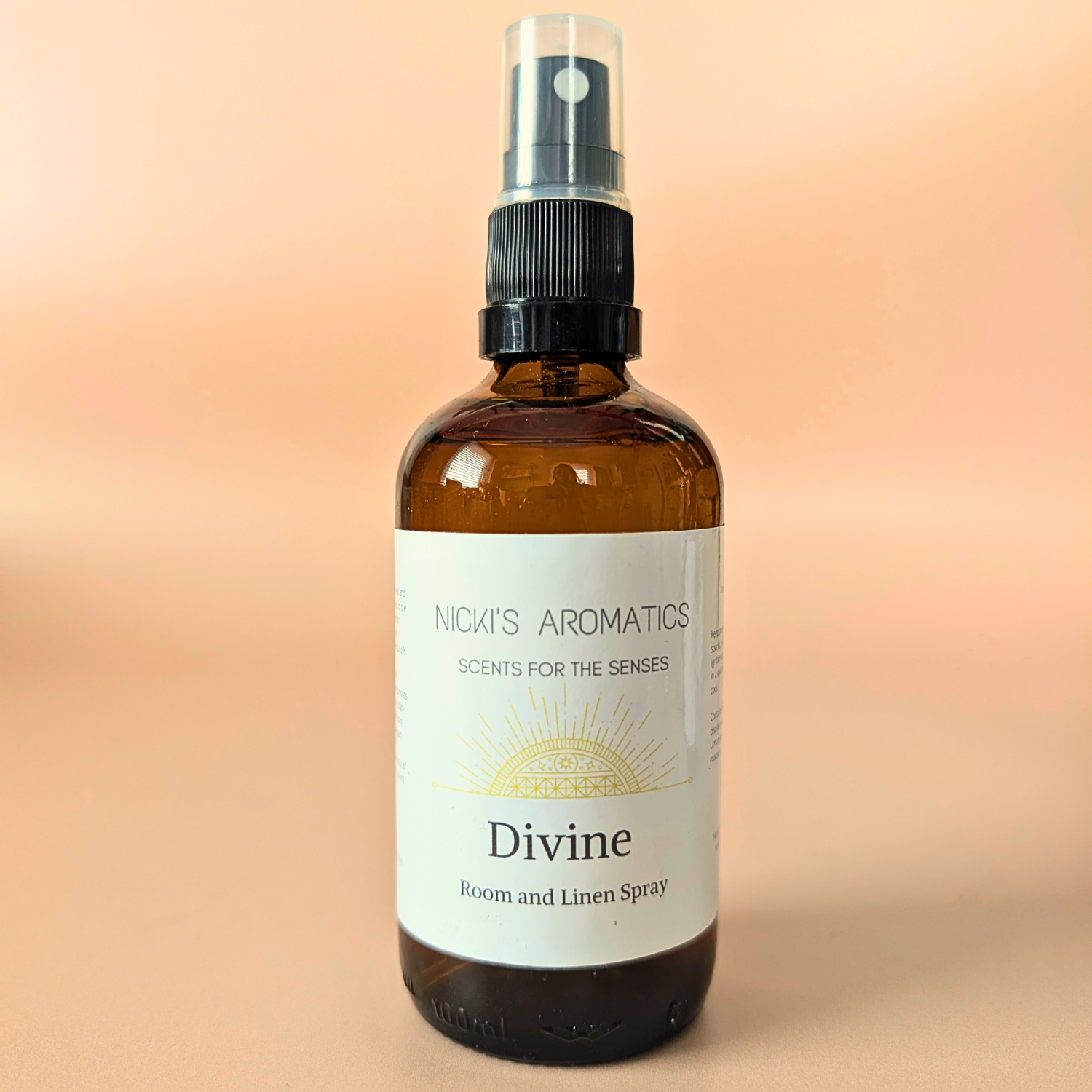 Divine natural room and linen spray with citrus, frangipani and basil in an amber glass bottle