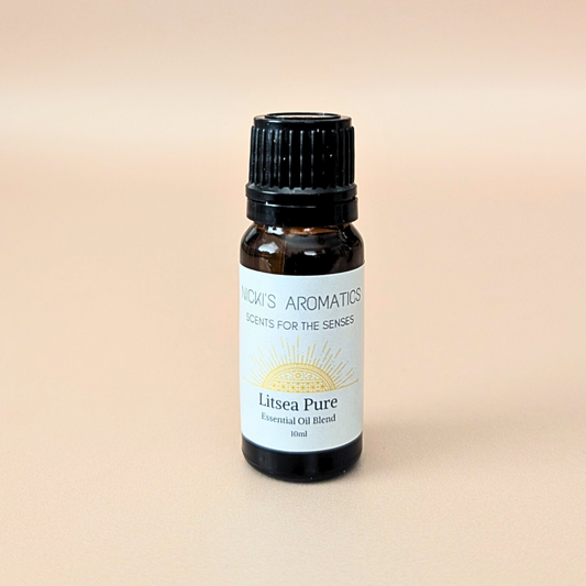 A 10ml amber glass bottle of 'Litsea Pure' essential oil blend by 'Nick's Aromatics', made with litsea, lime and bergamot, featuring a white label with a gold sun graphic and a black ribbed cap, set against a solid beige background.