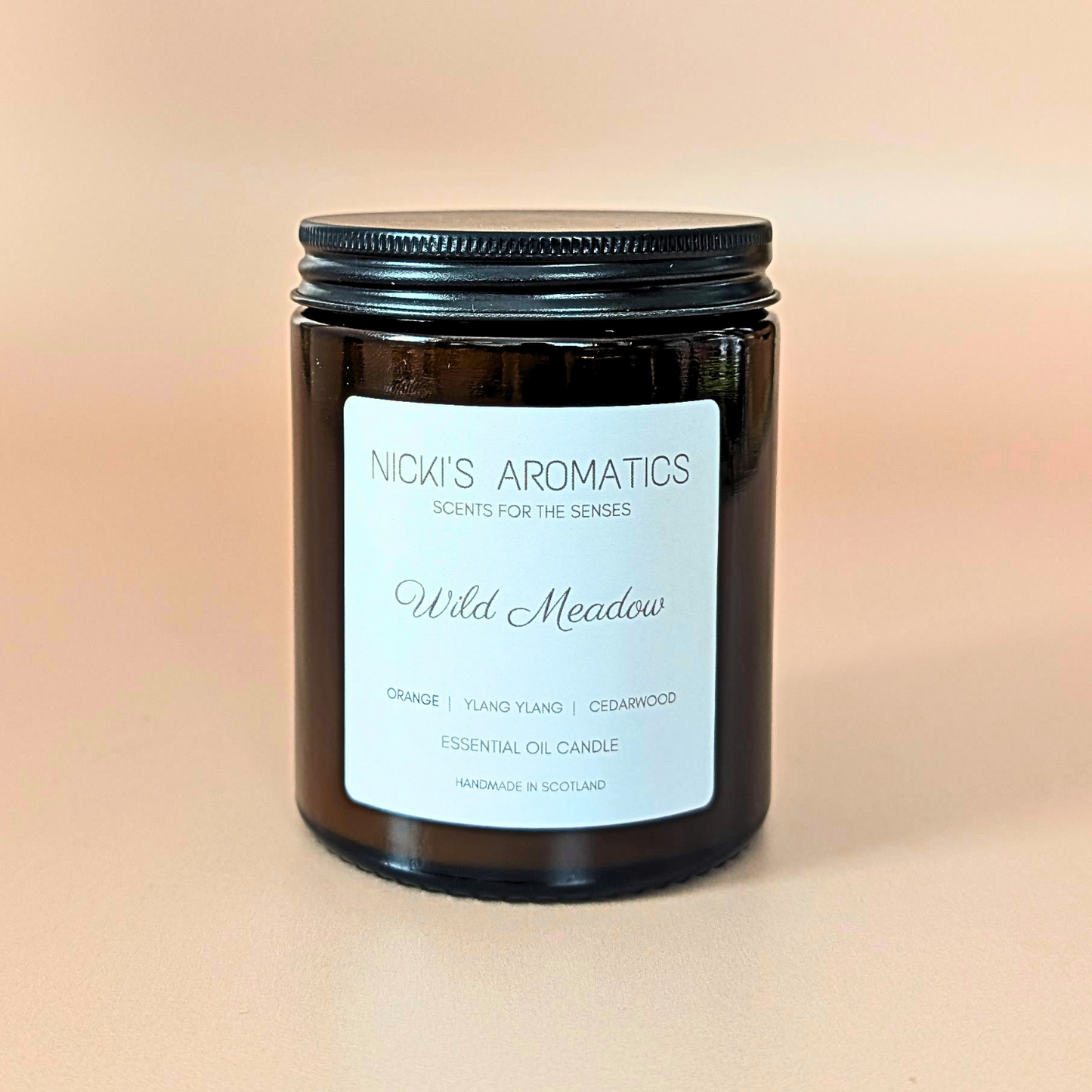 Wild Meadow essential oil candle with orange, ylang-ylang and cedarwood in an amber glass jar